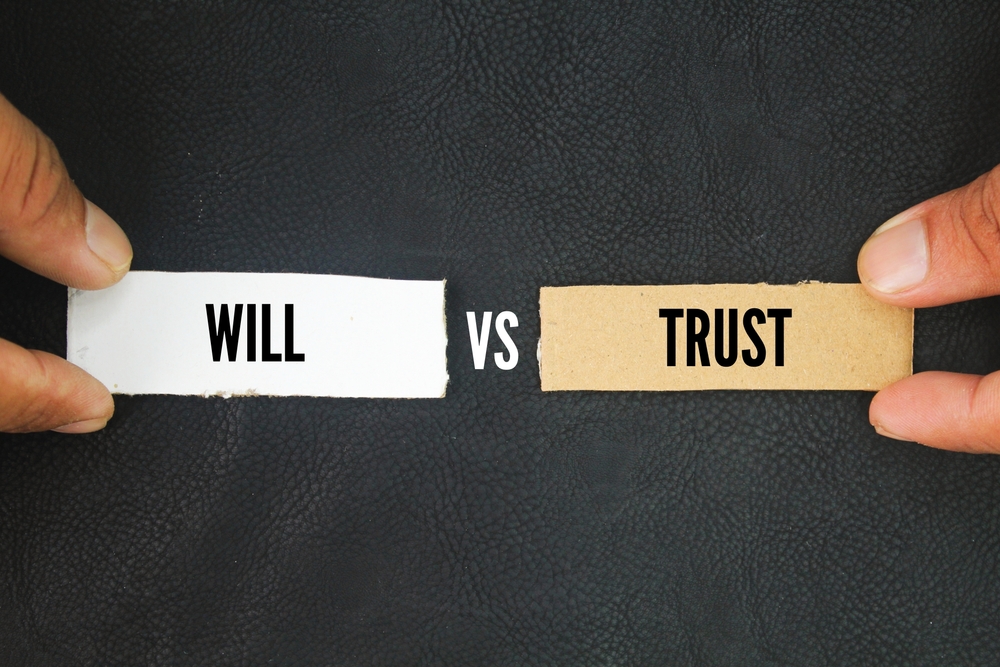 Paper on black background with the words trust vs will.
