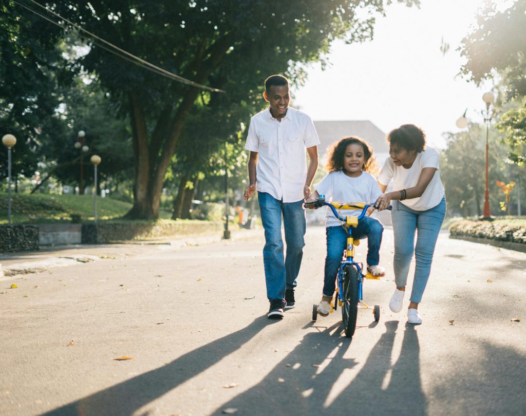 | crowl crowl Man Standing Beside His Wife Teaching Their Child How to Ride a Bicycle