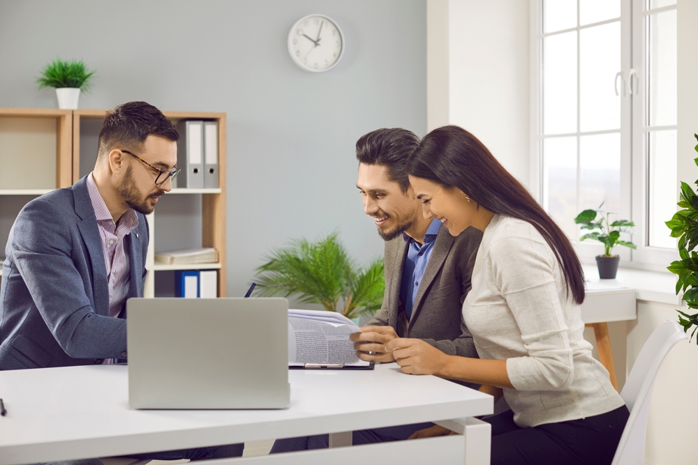 HappyYoungCoupleReadingBusinessDocumentAtMortgageNegotiatingHusband Young couple reviewing financial documents together while planning digital asset protection and estate matters
