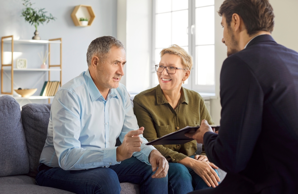 Senior couple discussing homeownership and property planning with a real estate professional.