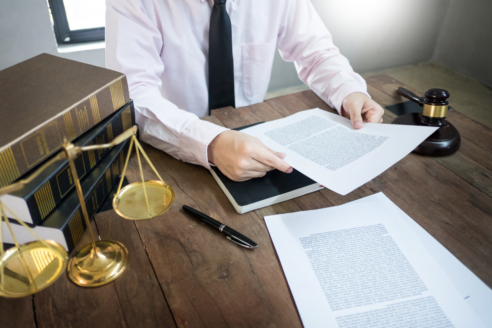 Lawyer reviewing legal documents in a courtroom during a criminal record expunction case